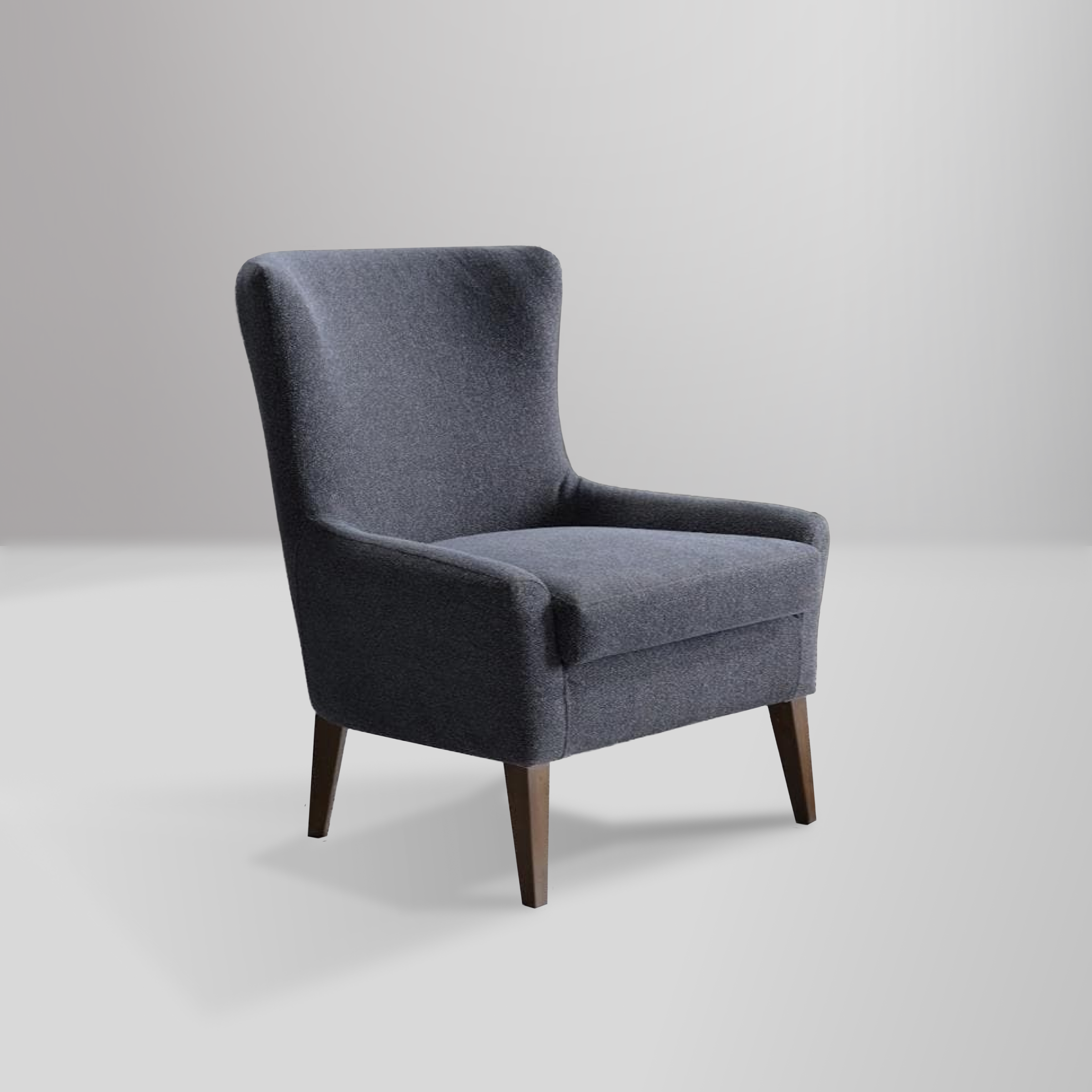 Canyon accent chair with a modern wingback design, low-profile arms, and natural wood legs