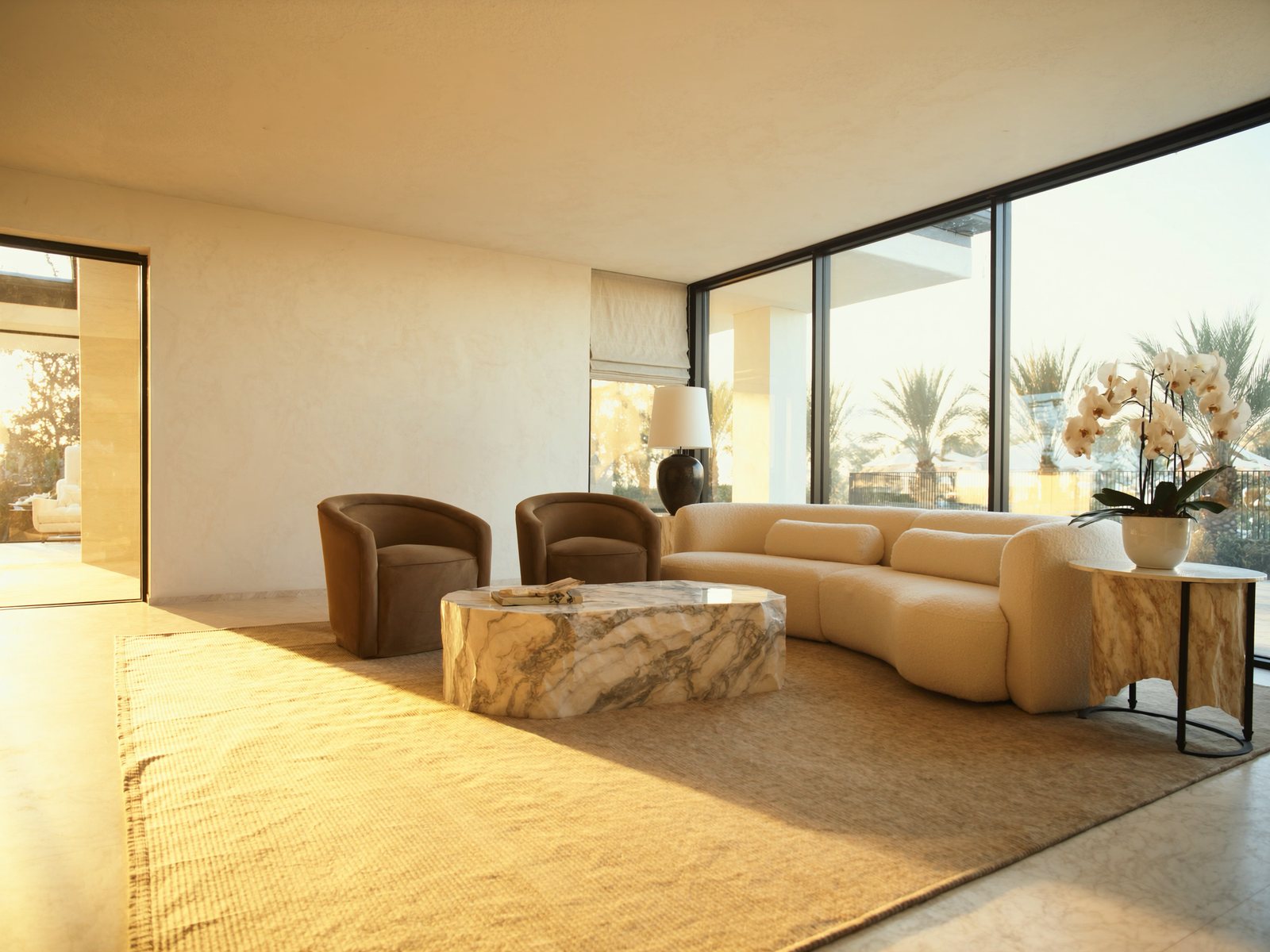 Sun-filled coastal-luxury living room in a Naples Florida waterfront home, with a curved bouclé sofa, marble coffee table, and floor-to-ceiling Gulf views